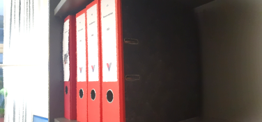 rote Ordner im Büroregal